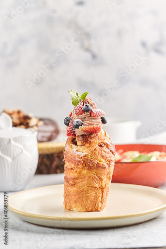 Cruffin dessert on plates panettones with icing berries and flowers cruffins with sugar and almonds Making Easter cakes and treats in a family business photo