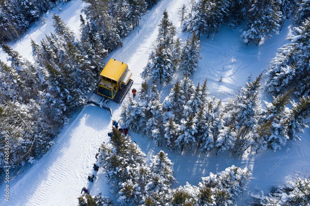 Aerial drone photo of a group of skiers and snowboarders in a snow cat in the Chic Choc Mountains of Quebec, Canada