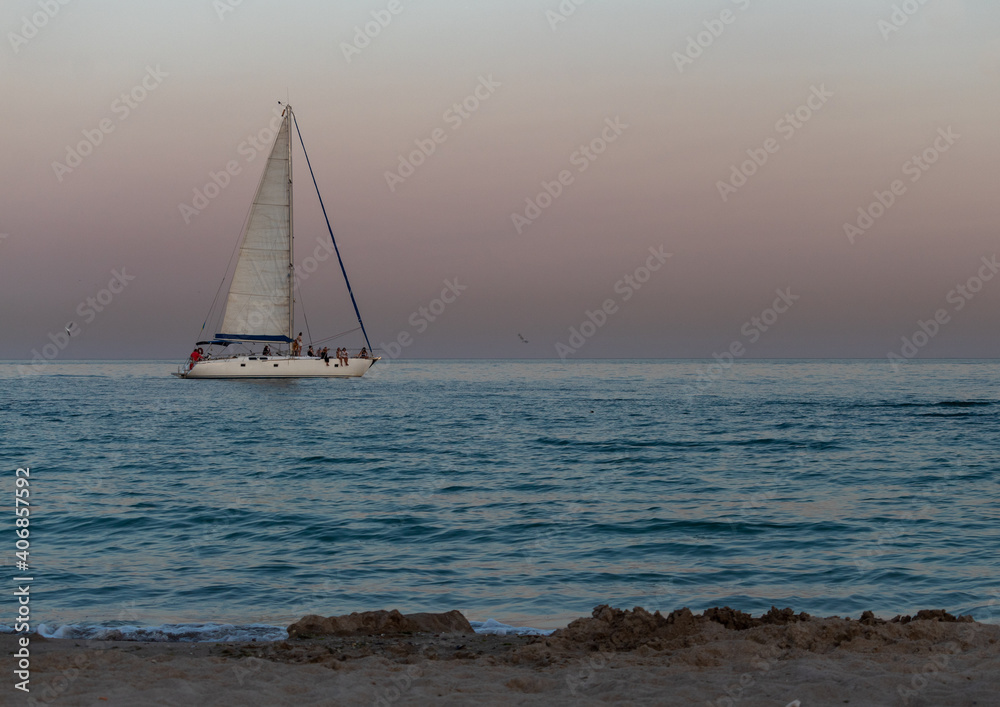 yacht against the background of the pink sky over the sea horizon