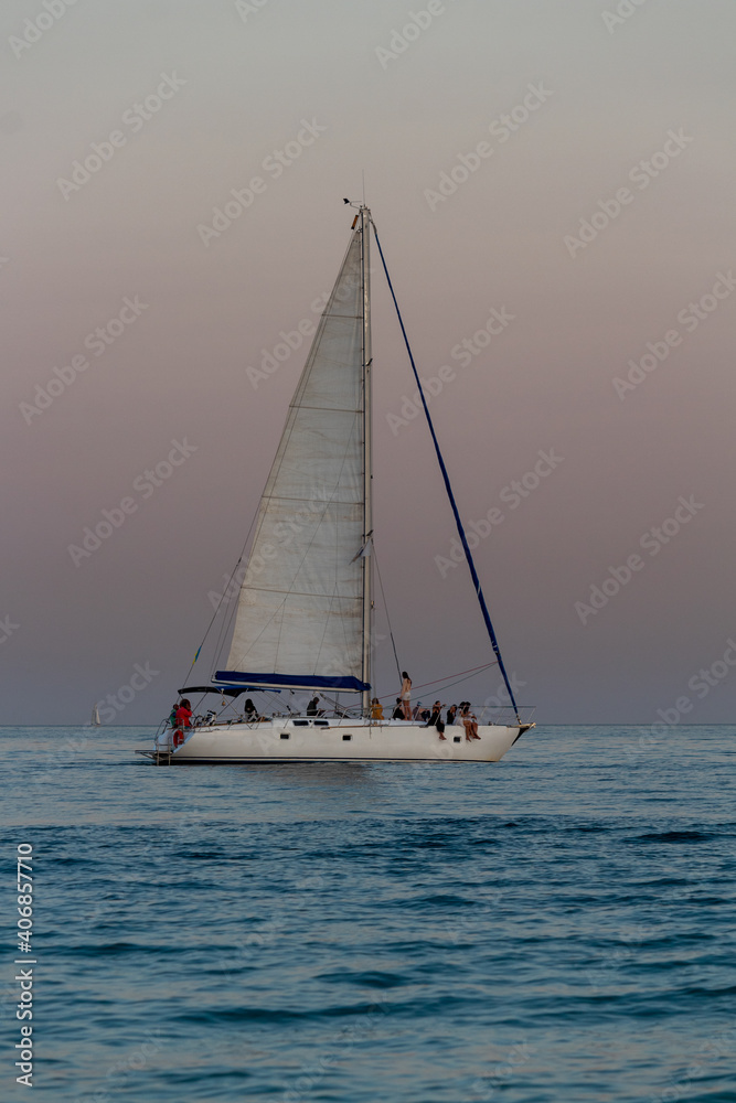 Obraz premium yacht against the background of the pink sky over the sea horizon