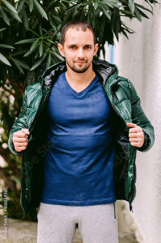 man wearing blue t-shirt mockup and jacket outdoors. Male in blank blue t-shirt v collar, front view outdoors. Design men t shirt template and mock-up for print 