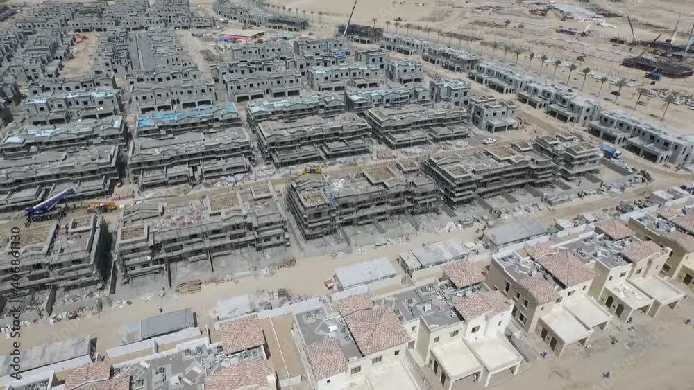 Aerial footage of luxurious residential villas and townhouses under construction with multitude of uniform structures build by using the tunnel form technology.