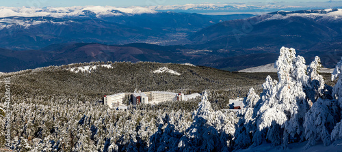 Cabeza de Manzaneda ski resort covered in snow among pine trees on a sunny day