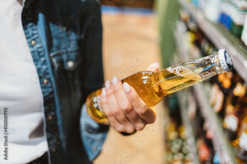 Fototapeta Naklejka Na Ścianę i Meble -  Close-up of female hand holding glass bottle