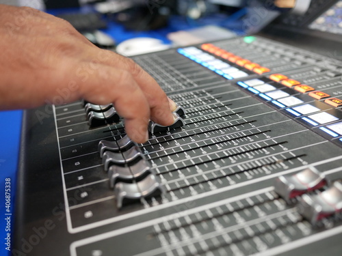 hand adjusting audio mixer in studio.