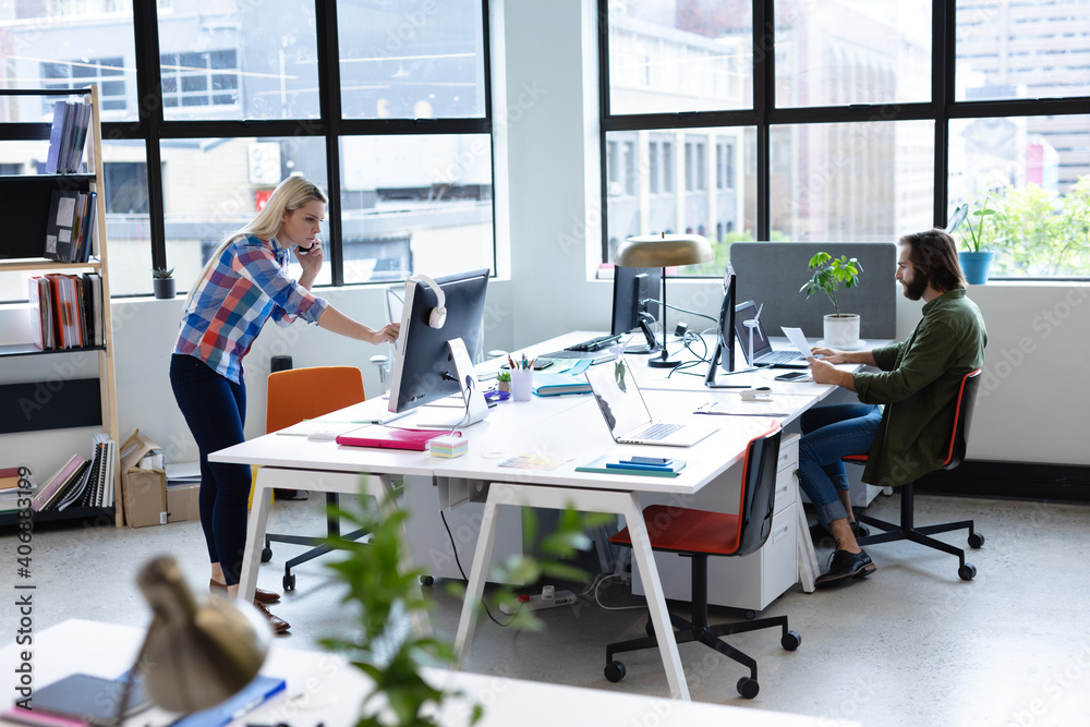 Two caucasian business people working in creative office