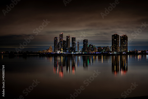 City skyline across the water at night with reflection photo