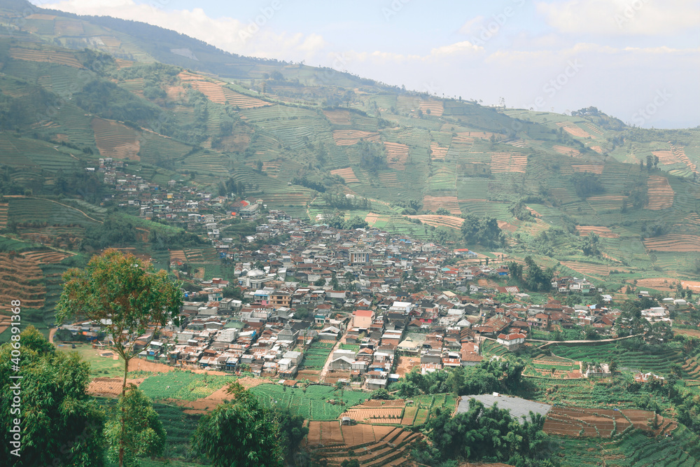 Aerial view of Dieng Plateau with town and hill in background