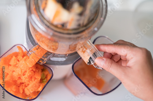 Bilde på lerret Woman juicing cold pressed juice and pouring into bottle