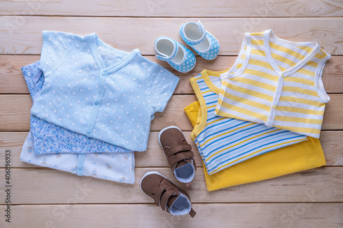 The clothes for kids for babies set with shoes on the wooden table.