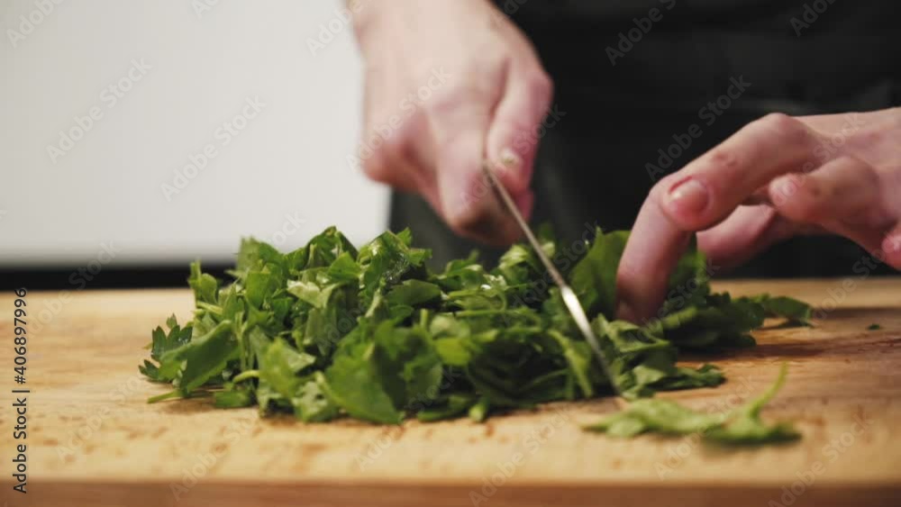 Cutting greens. Someone is chopping parsley. The chef is chopping cilantro for cooking. Cutting greens. Someone is chopping parsley. The chef is chopping cilantro for cooking.