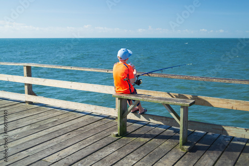 Little boy fishing on the pier