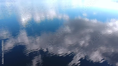View from the height of the reflection of clouds in the water on the lake. Waves on the lake, view from a height
