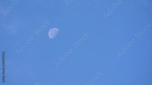 Clouds float by during the day and the new moon peeks out from behind them