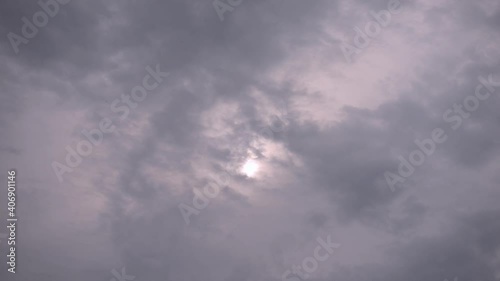 Floating clouds on the fore silhouette of the sun close up