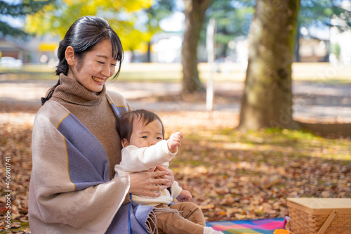 秋の公園で遊ぶ赤ちゃんとママ 