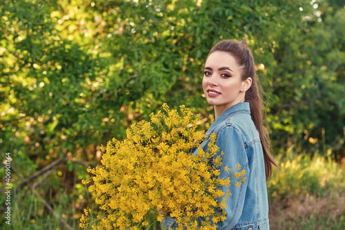 Happy young woman in denim jacket and dress in nature . Women s casual clothing .