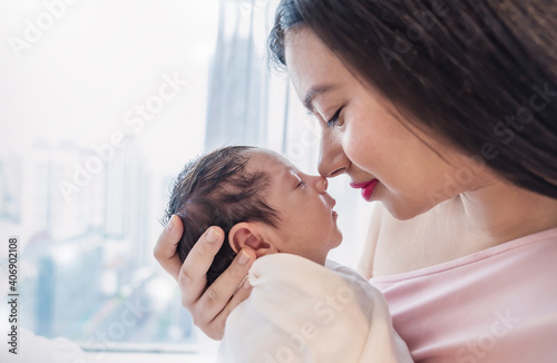 Closeup portrait of beautiful young asian mother kissing nose to nose with newborn baby. Mom looking at her daugher. Healthcare and medical family love lifestyle nursery mother’s day concept