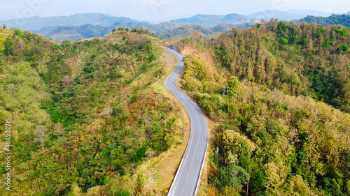 Aerial view photo curve way of asphalt road through in mountain.
