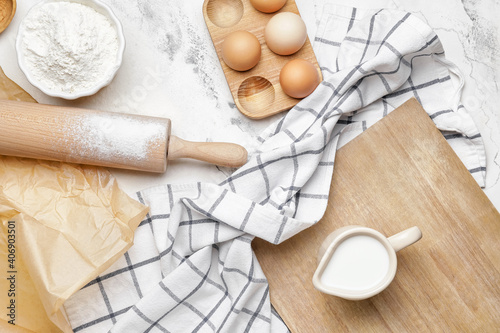 Ingredients for dough and rolling pin on light background