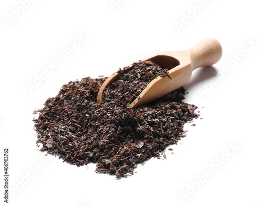 Scoop with dry black tea leaves on white background