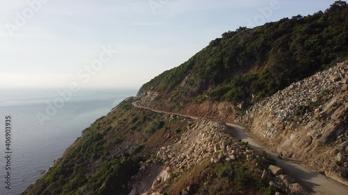 Wallpaper Mural Aerial view of motorist driving motorbike on dangerous coastal cliffside road. Torontodigital.ca