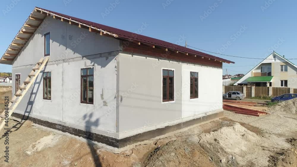 Aerial view of façade of unfinished modern energy efficient house of foam blocks panels with roof with metal tile sheets. House in village. Sunny day
Aerial view of façade of unfinished modern energy efficient house of foam blocks panels with roof with metal tile sheets. House in village. Sunny day