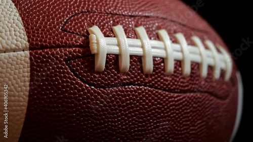 American football extreme close up on laces against black background