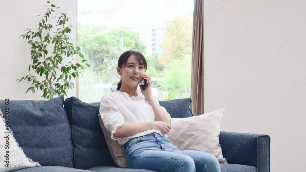 ソファーでスマホを使う女性 ソファーでスマホを使う女性