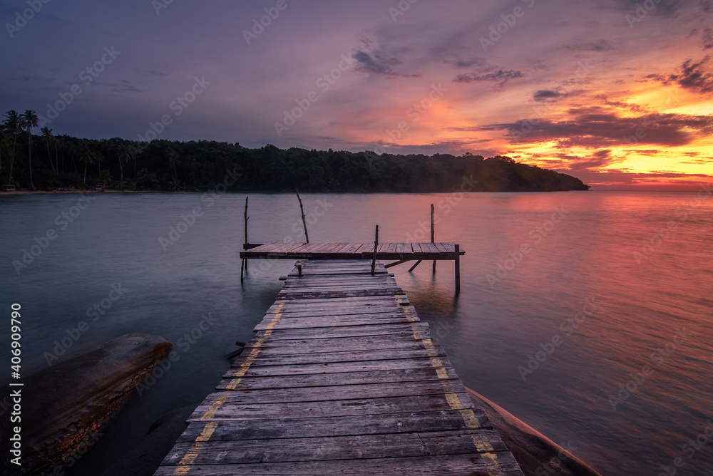 Fototapeta premium The long-exposure scenery of a beautiful twilight sky in sunset time over the wooden pier in Koh Kood island, Trat, Thailand.