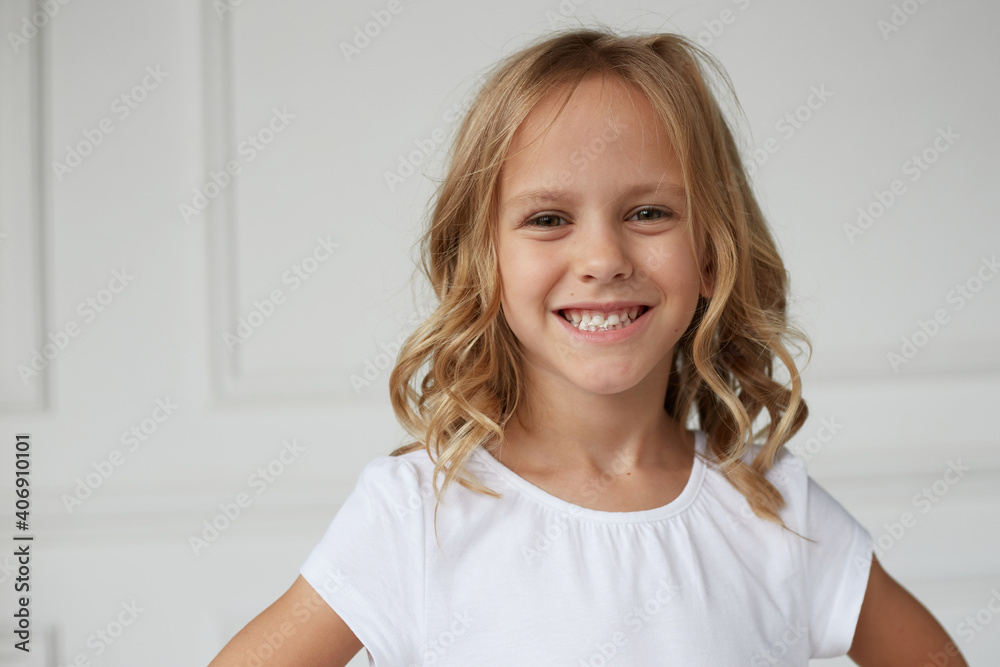 Close up image of an adorable smiling little girl showing her teeth chewing a gum, white background. Close up image of an adorable smiling little girl showing her teeth chewing a gum, white background.