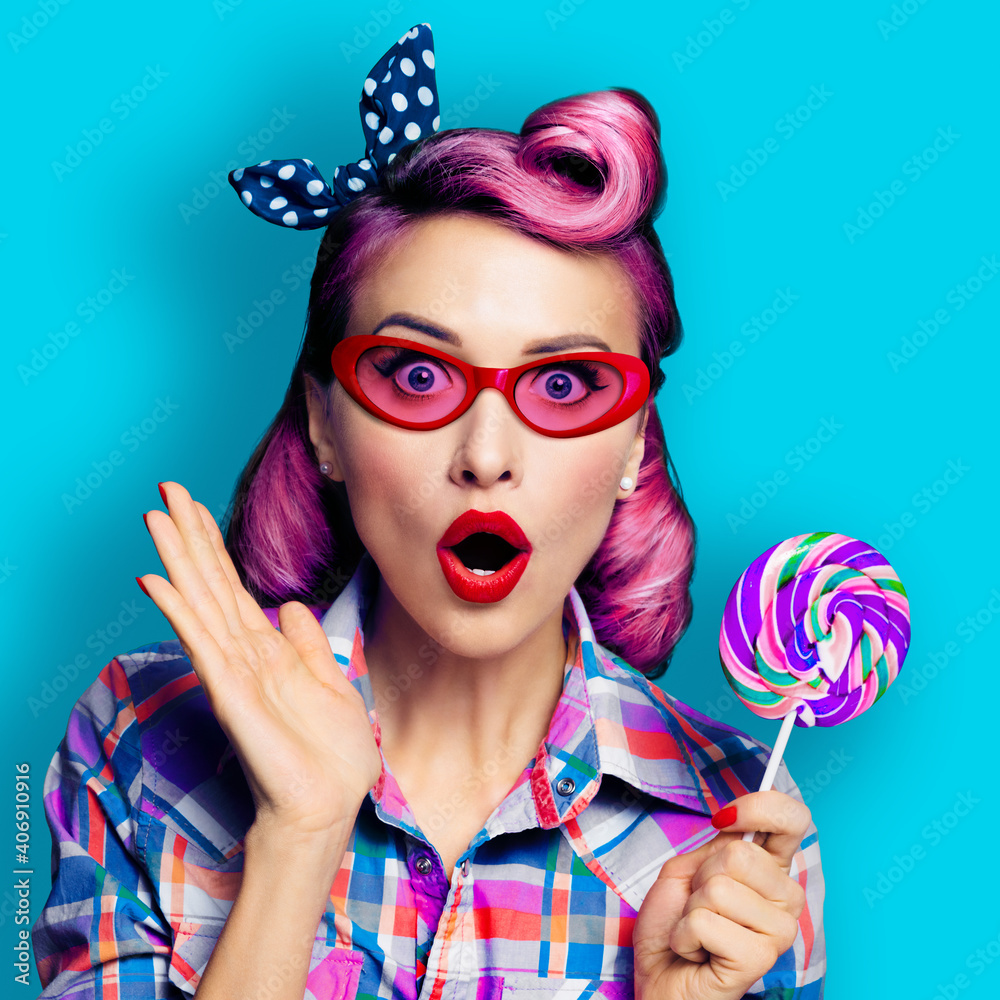 Purple head excited very surprised woman in red glasses with lollipop. Pinup girl with wide opened mouth, eyes. Retro fashion and vintage concept. Aqua blue color background square composition.