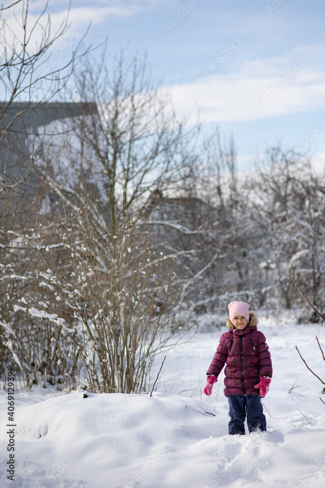 A child girl on a walk in a winter park