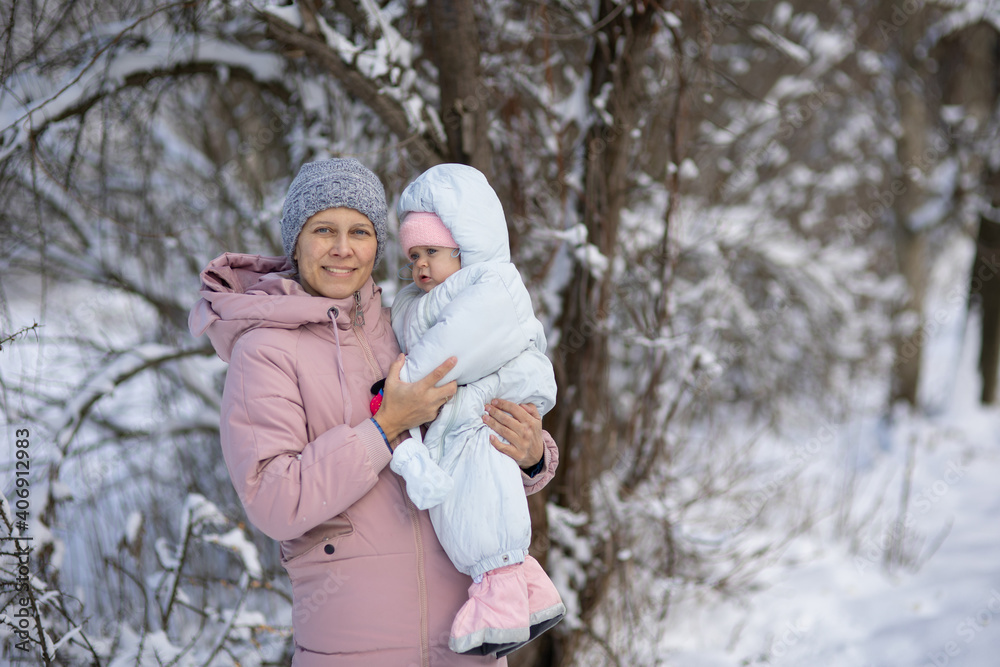 A woman with a baby on a walk in winter A woman with a baby on a walk in winter