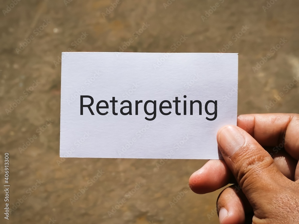 Selective focus image with noise effect hand holding white card with text RETARGETING.Business concept. Selective focus image with noise effect hand holding white card with text RETARGETING.Business concept.