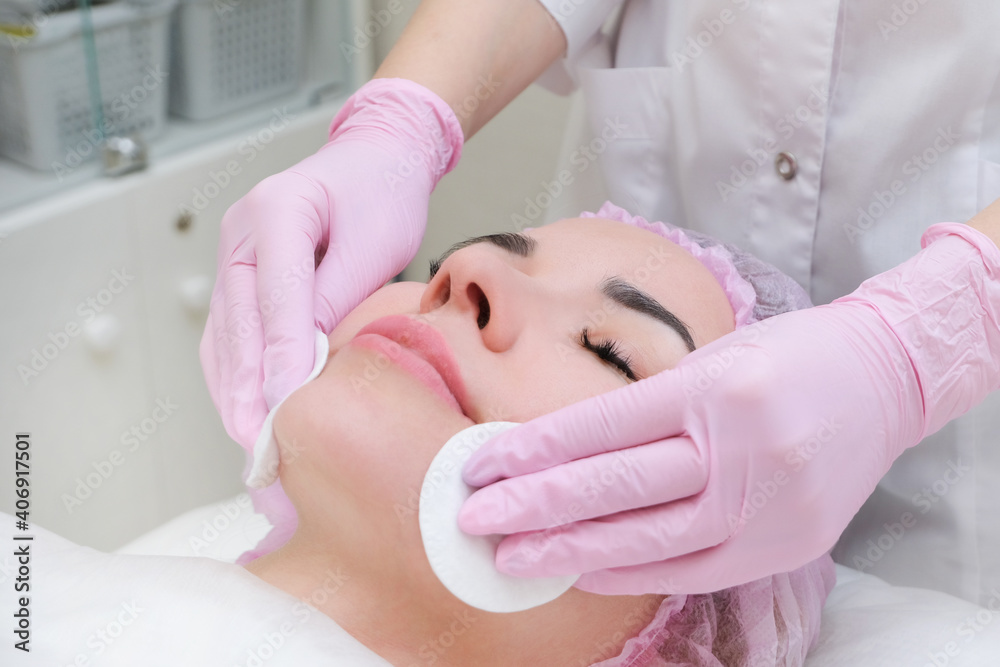 cosmetology. Close up picture of lovely young woman with closed eyes receiving facial cleansing procedure cosmetology. Close up picture of lovely young woman with closed eyes receiving facial cleansing procedure