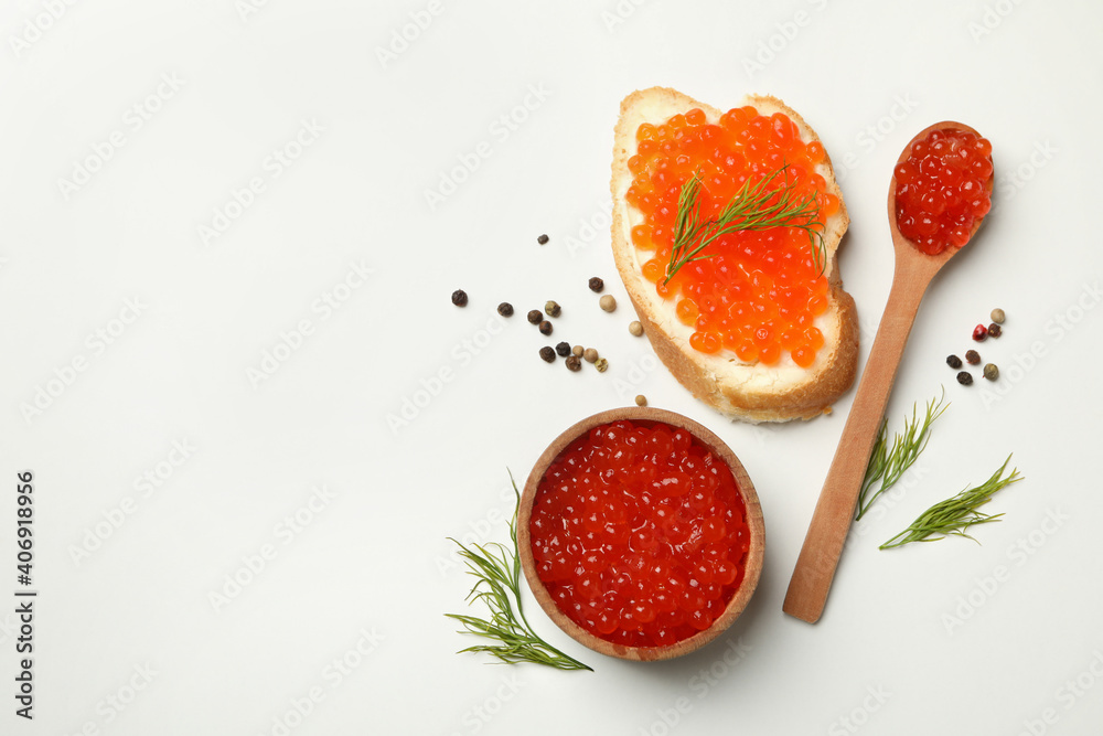 Sandwich, wooden bowl and spoon with caviar on white background, space for text Sandwich, wooden bowl and spoon with caviar on white background, space for text