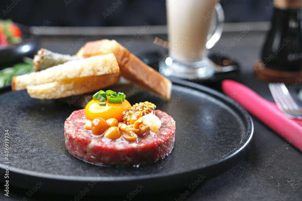 Beef tartare with yolk, pickled mushrooms and mustard. Traditional appetizer.
Serving the dish. Beef tartare with yolk, pickled mushrooms and mustard. Traditional appetizer.
Serving the dish.