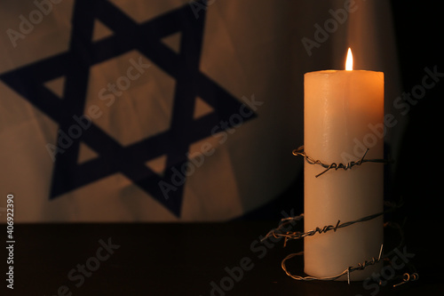 Obraz na plátně Barbed wire and burning candle on black background