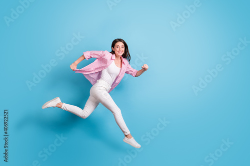 Fototapeta Naklejka Na Ścianę i Meble -  Full length profile photo of pretty carefree person jump run speedy good mood isolated on blue color background