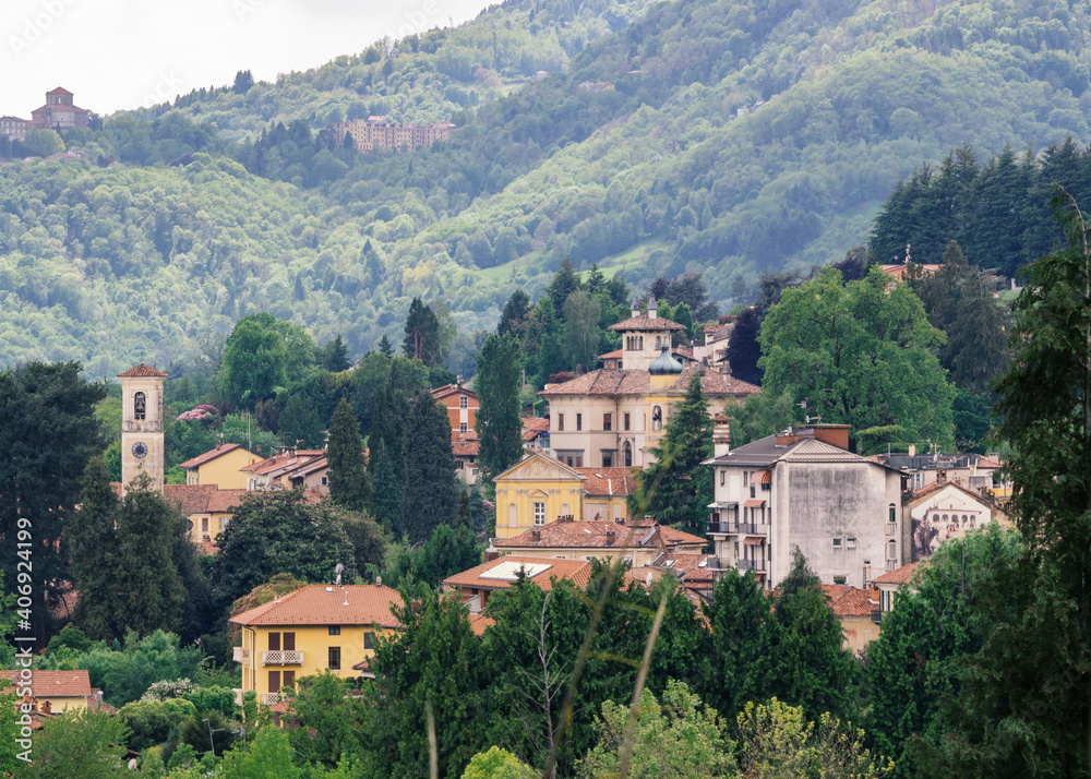 aerial view of a village with few houses on the hills of Piedmont immersed in the green of the woods.Biella, Italy.