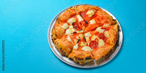 A Pepperoni pizza on a blue background isolated. Traditional Italian cuisine concept  pizza Margarita or Margherita