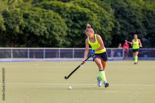 Young field hockey female player in attack