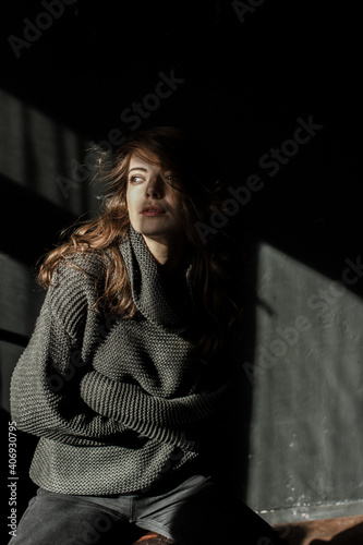 Sensual portrait of beautiful woman in sun light. Dark background 