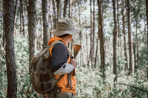 Male holding map for check location adventure in forest, Holidays concept