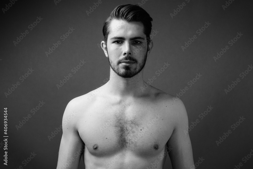 Young handsome bearded man shirtless against gray background Young handsome bearded man shirtless against gray background