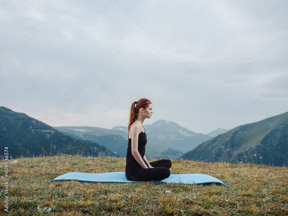Woman in leggings meditate sitting on a rug on nature in the mountains