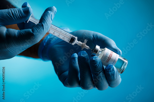 Foto mani di un medico con guanti in lattice, prelevano il vaccino anti-covid con una