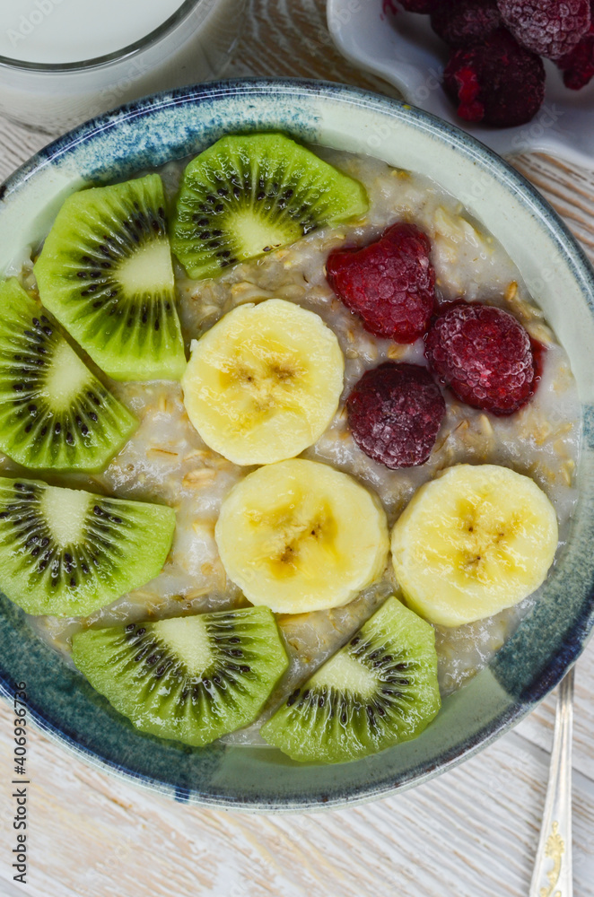 Healthy food for breakfast top view flat lay. Oatmeal porridge with berry, kiwi and banana fruit Healthy food for breakfast top view flat lay. Oatmeal porridge with berry, kiwi and banana fruit