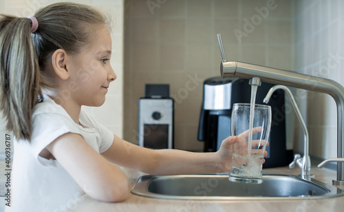 Child open water tap. Kitchen faucet. Glass of clean water. Pouring fresh drink. Hydration. Healthy lifestyle. Water quality check concept. World water monitoring day. Environmental pollution problem